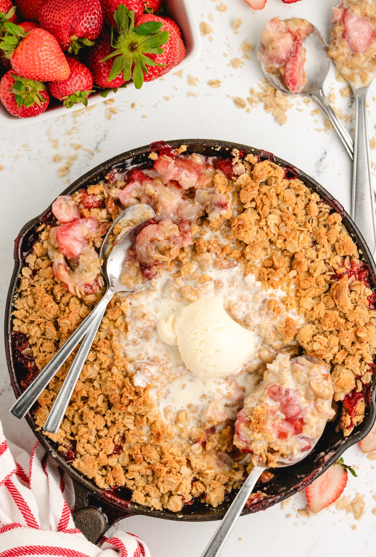 Warm strawberry and banana dessert with oat topping Golden oat topping over soft baked strawberries and bananas in a warm dessert skillet.