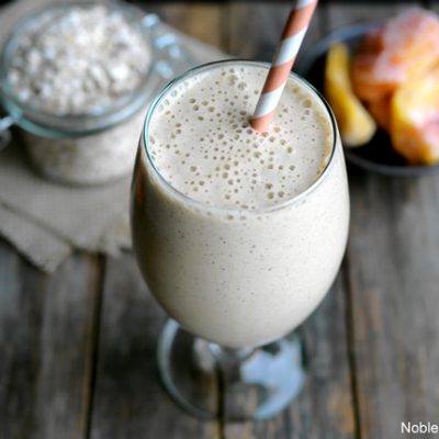 Overhead of peach smoothie in a glass with a straw.