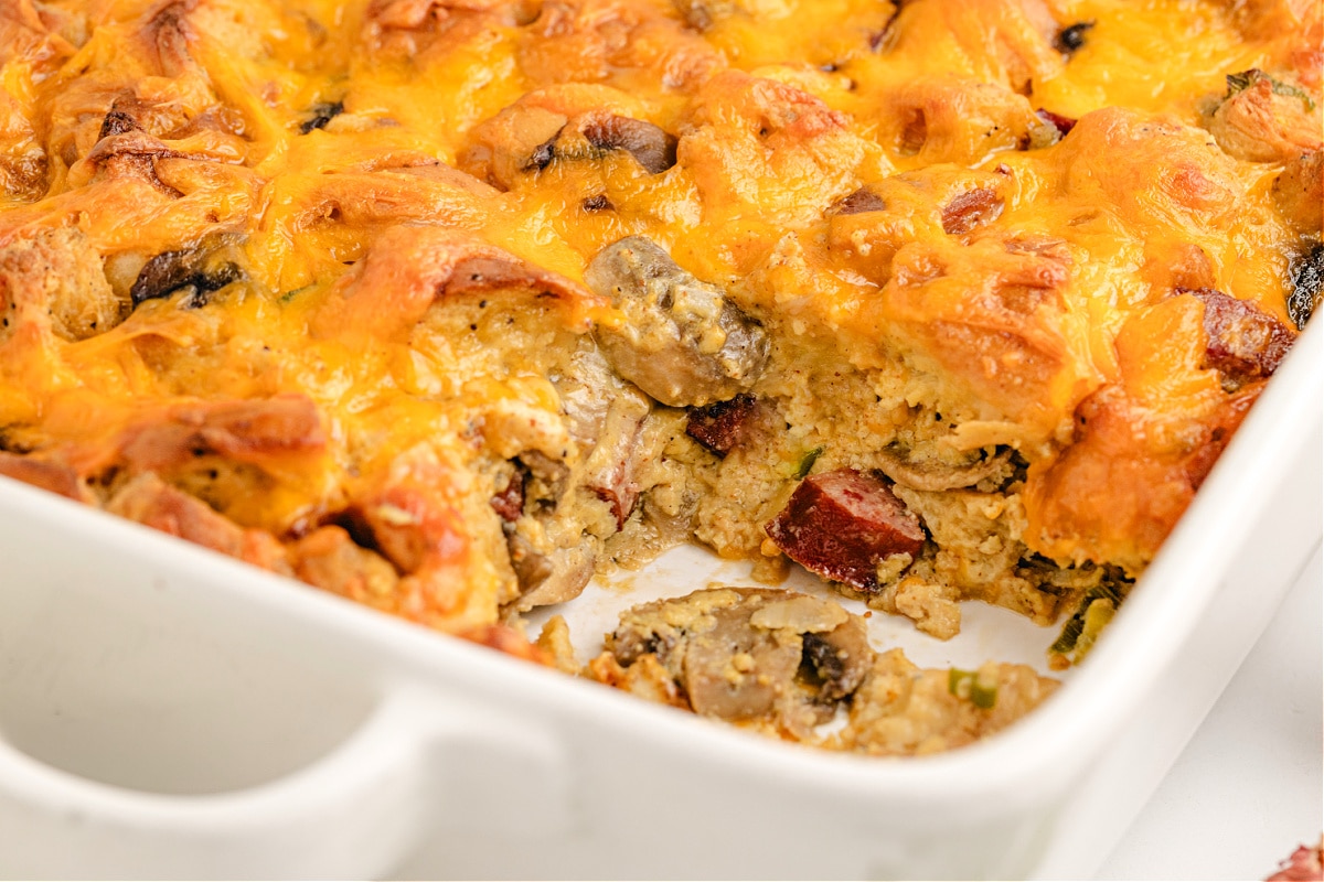 Baked bagel breakfast casserole with kielbasa, mushrooms, and melted cheddar.