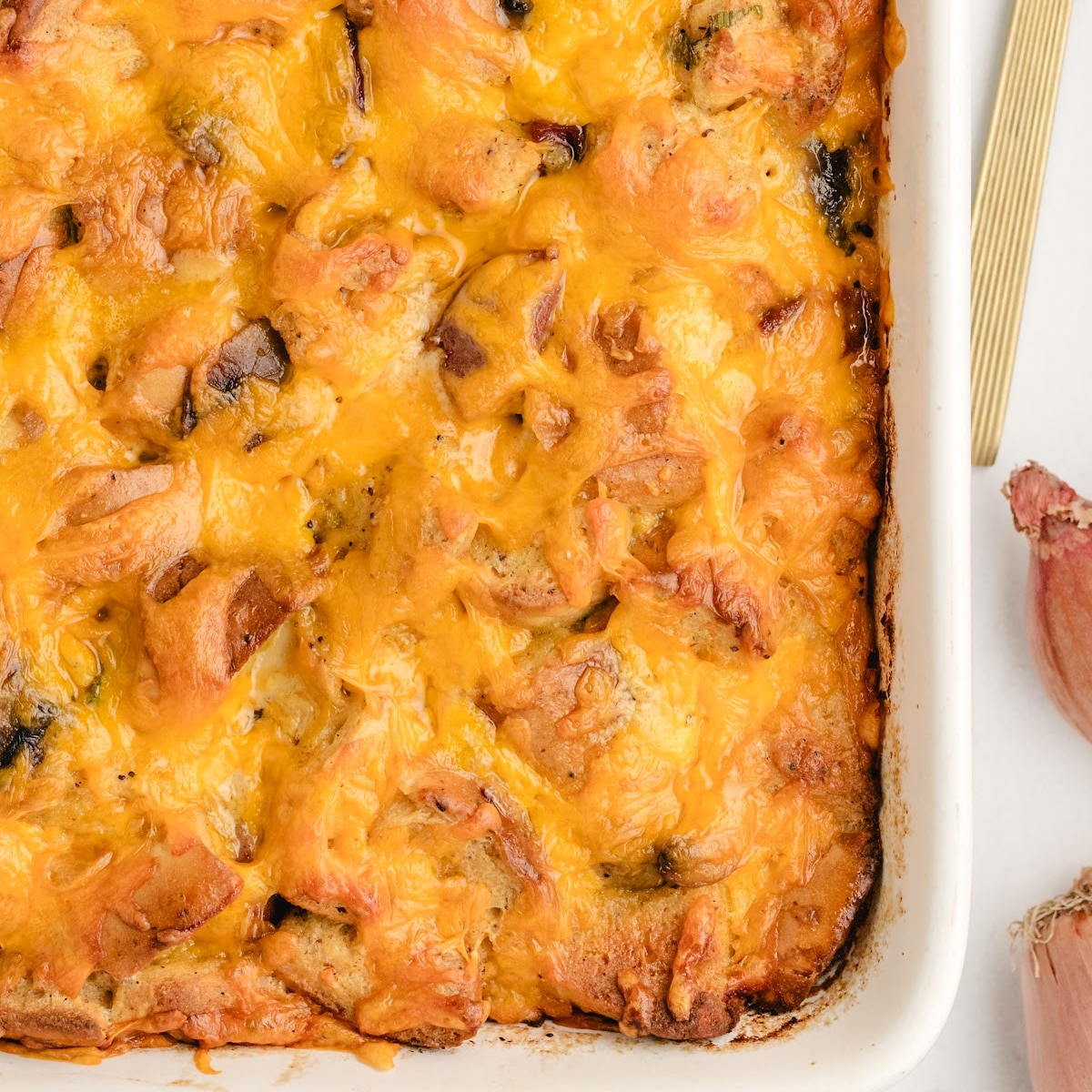 Overhead view of bagel breakfast casserole baked golden with cheddar and kielbasa.