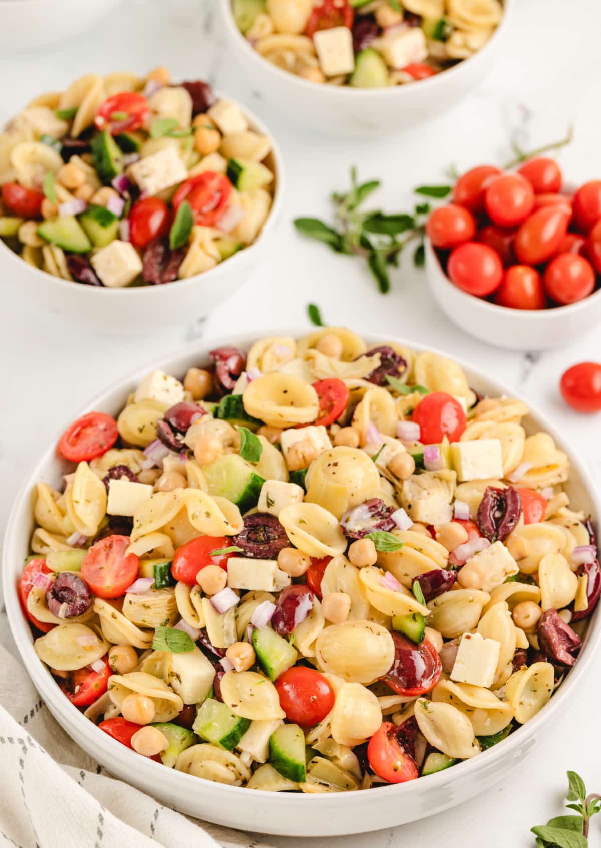 Greek Pasta Salad meal prep A bowl of Greek pasta salad with orecchiette, feta, olives, cucumbers, and tomatoes, tossed in a tangy dressing.