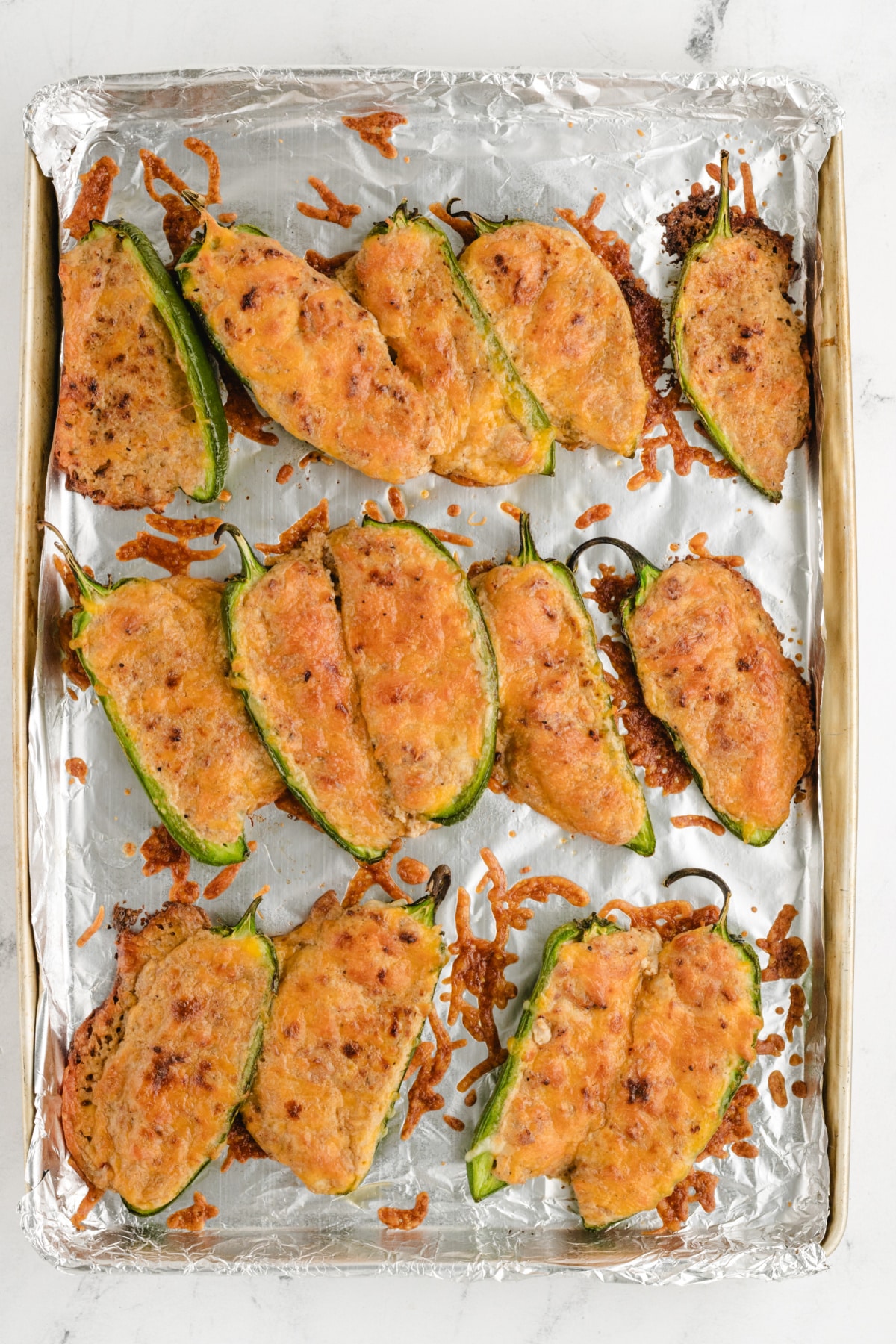 Ground Turkey Stuffed Jalapenos right out of the oven Freshly baked stuffed jalapeños arranged on a tray, showing the creamy, spicy filling.