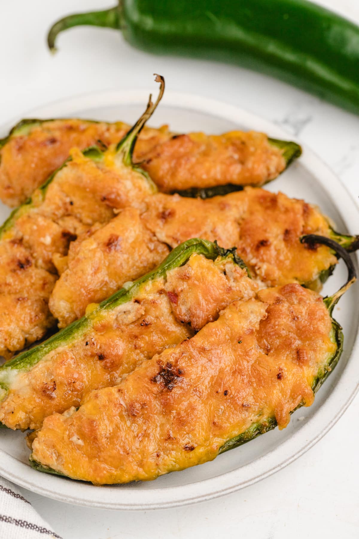Ground Turkey Stuffed Jalapenos A plate of ground turkey jalapeños stuffed with seasoned turkey and cheese, highlighting the texture of the filling.