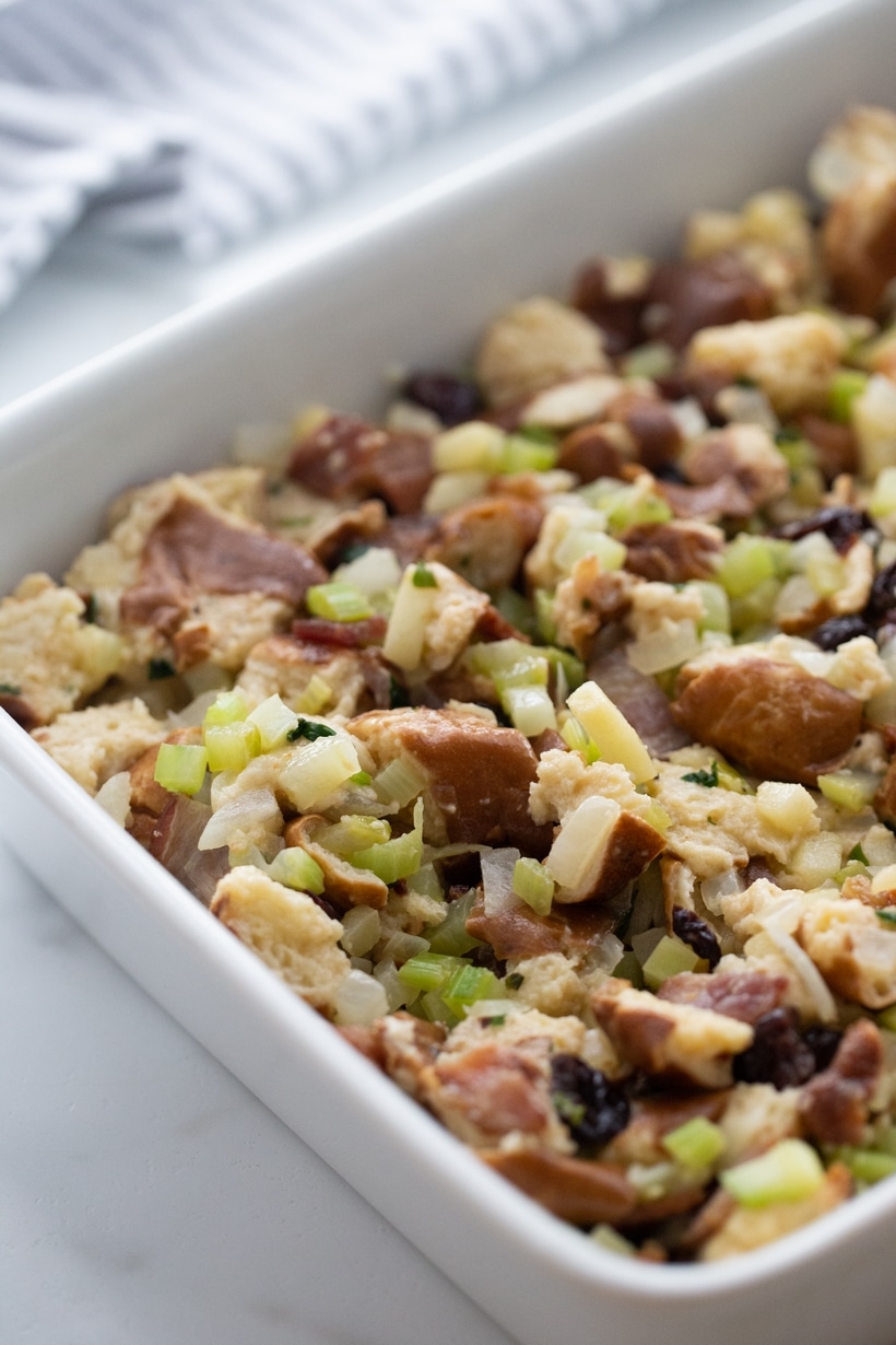 Unbaked pretzel bread stuffing mixture spread evenly in a white baking dish.