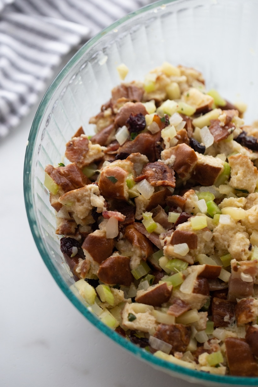 Unbaked pretzel bread stuffing mixture in a clear glass bowl.