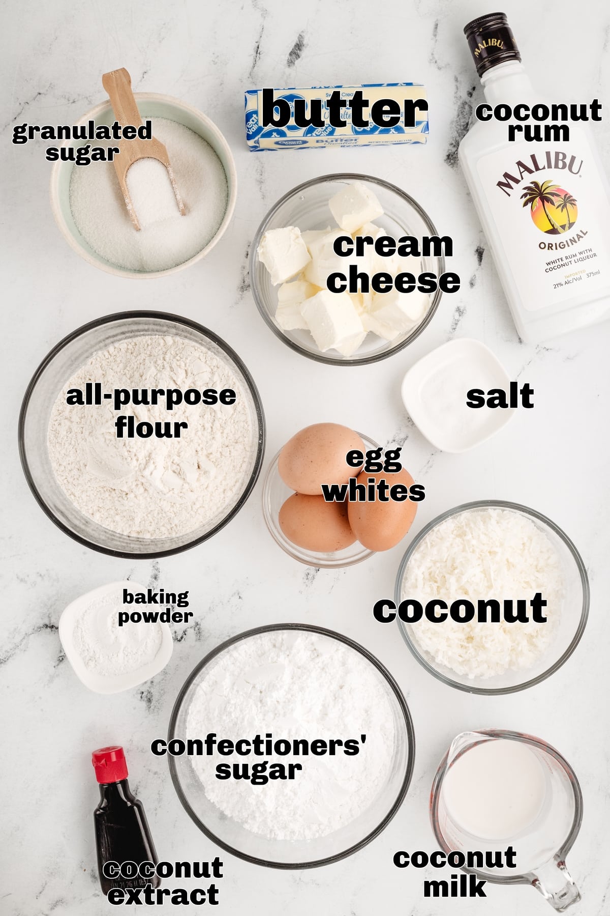 Coconut Cupcakes with Coconut Cream Cheese Frosting Ingredients including coconut milk, shredded coconut, coconut rum, and coconut extract laid out on a kitchen counter.
