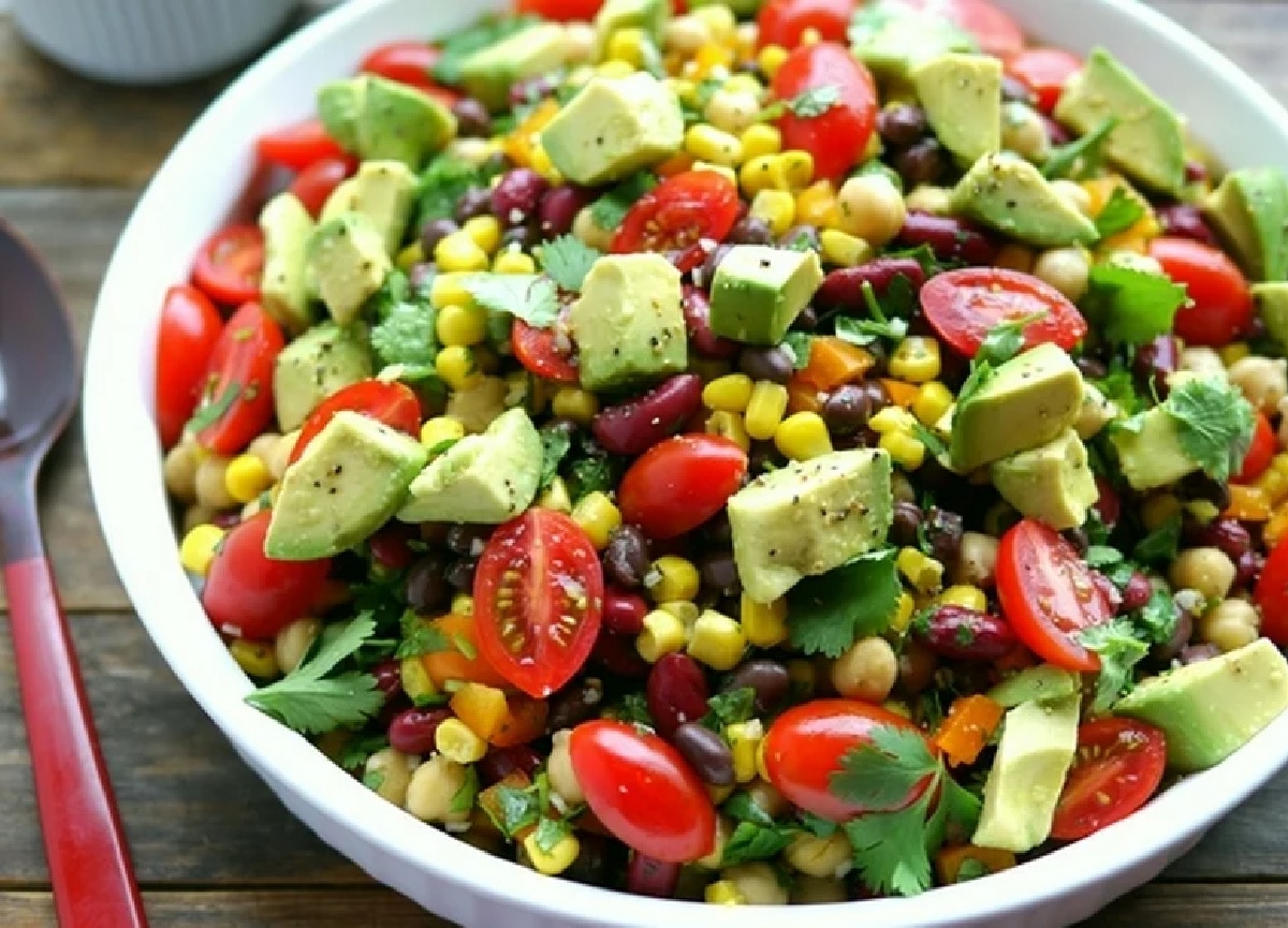 Overhead shot showcasing the mix of colorful ingredients, with the orange bell pepper and sweet corn standing out against the darker beans.