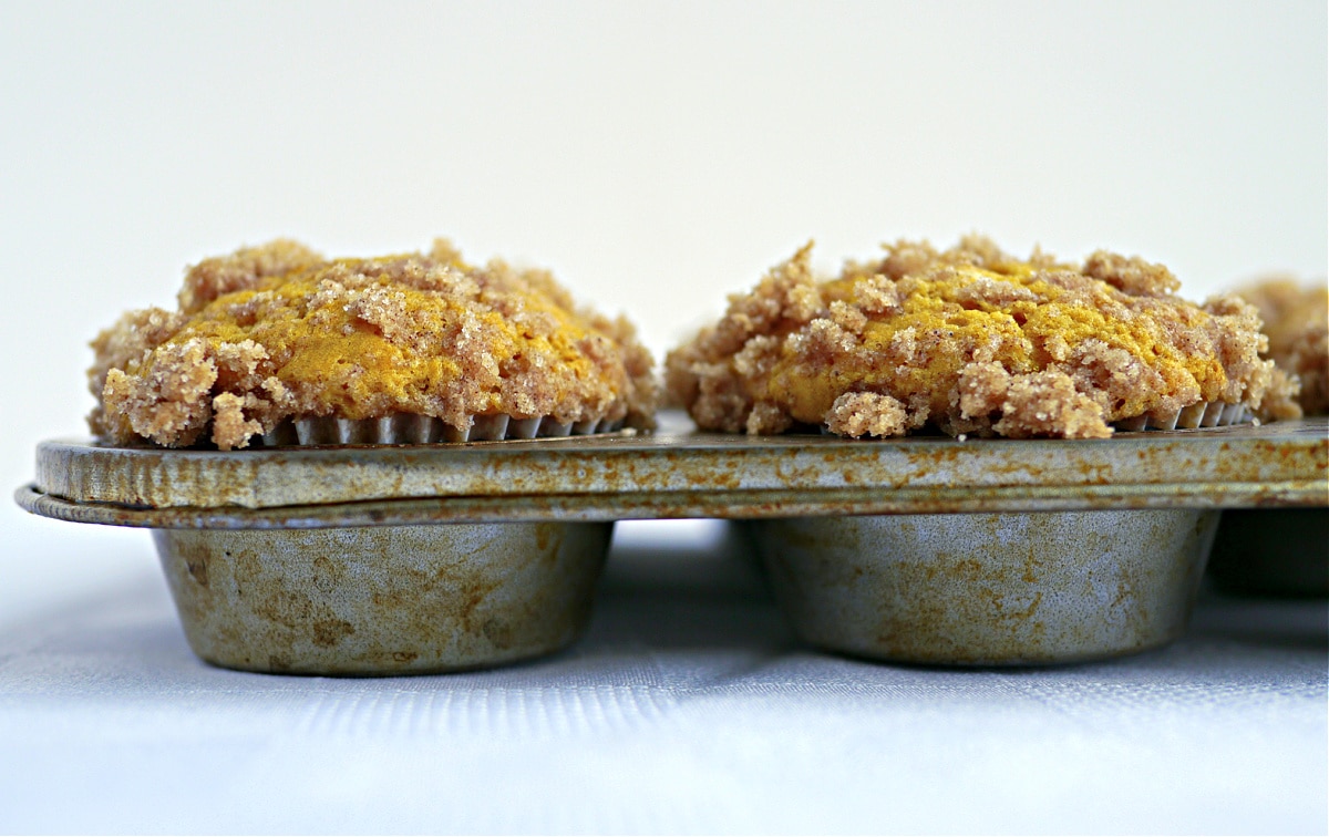 buttermilk pumpkin muffins with streusel topping buttermilk pumpkin muffins with cinnamon streusel topping in striped liners on white surface