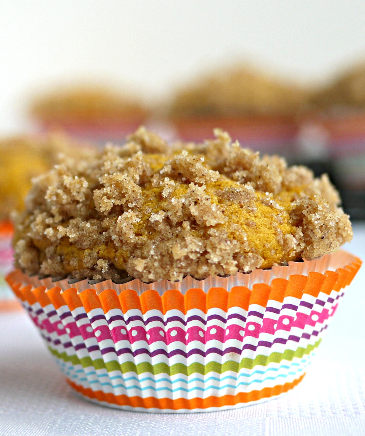 pumpkin buttermilk muffin with streusel topping pumpkin buttermilk muffin with buttery streusel topping in a colorful striped liner