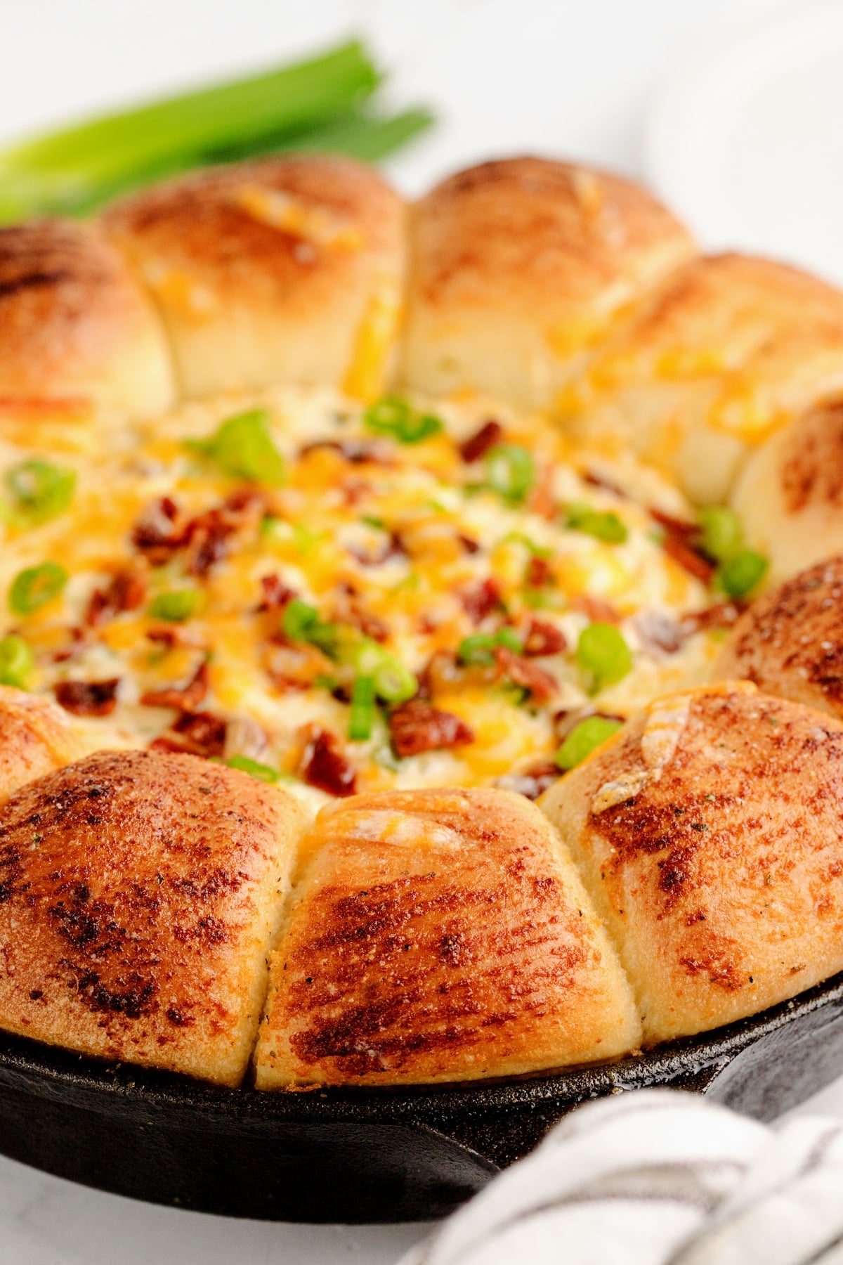 Sour Cream Bacon Ranch Ring Dip in Cast Iron Skillet Close-up of a golden-brown sour cream bacon ranch ring dip in a cast iron skillet.