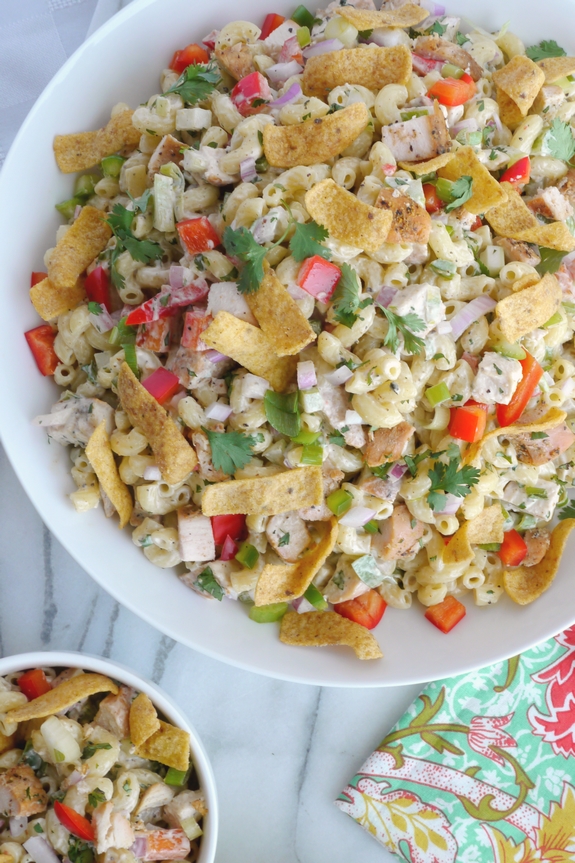 This Kicked-Up Chicken-Macaroni Salad recipe will impress your family and friends at your next picnic, BBQ or tailgate. This chicken macaroni salad pairs well with almost anything and will have your guests begging for more. Overhead view of Kicked-Up Chicken-Macaroni Salad in two bowls with a colorful napkin.
