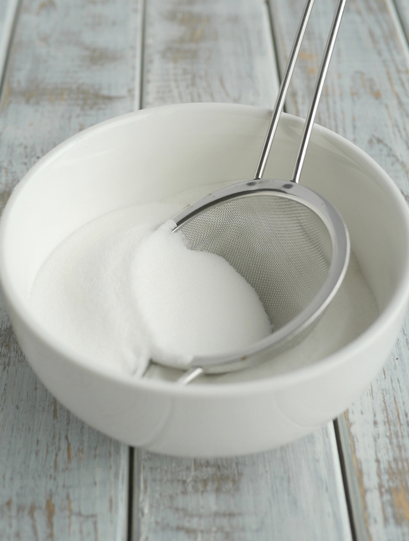 Bowl of sugar with a sifter inside