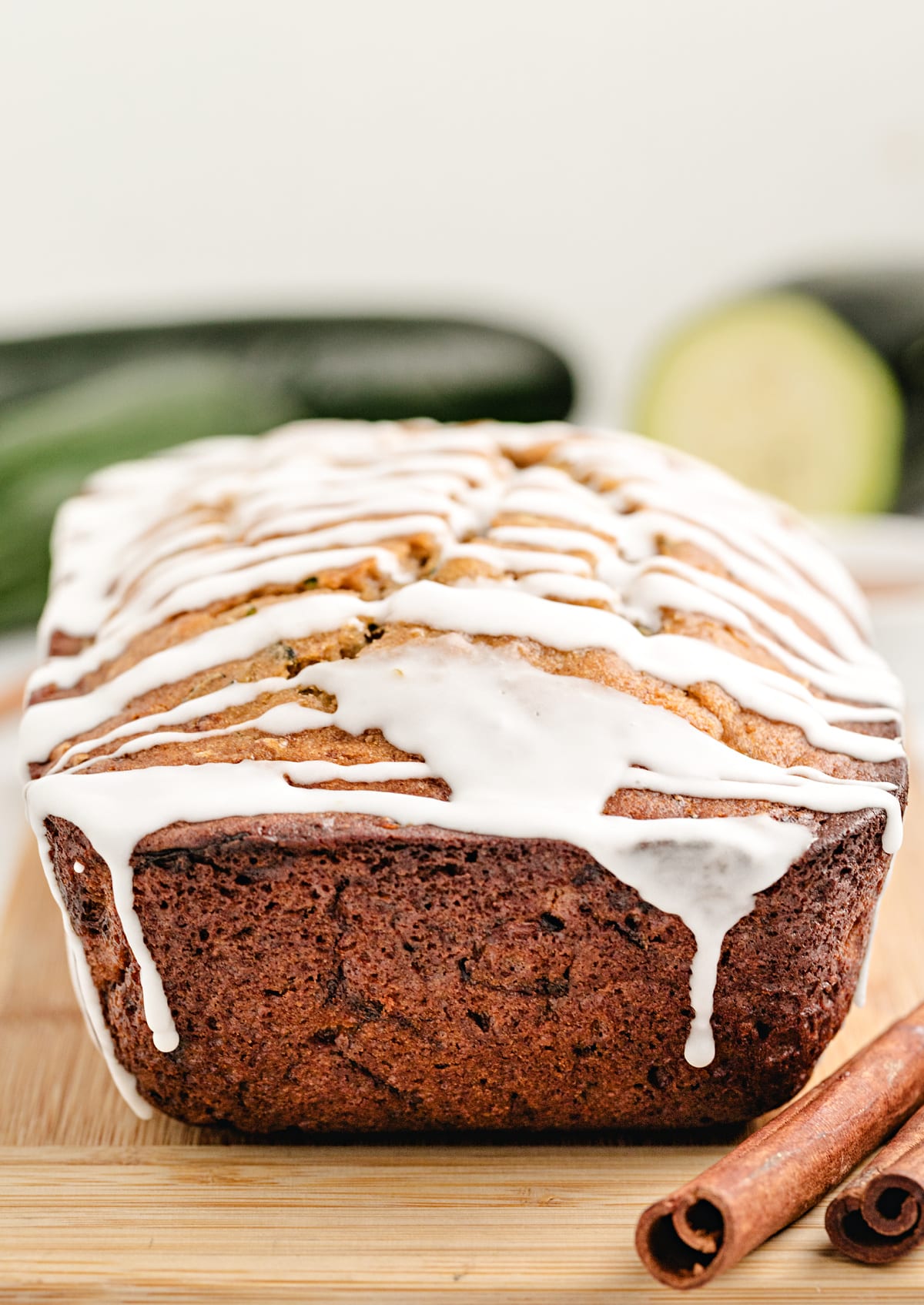 Freshly baked honey zucchini loaf with icing drizzle, whole zucchini in background