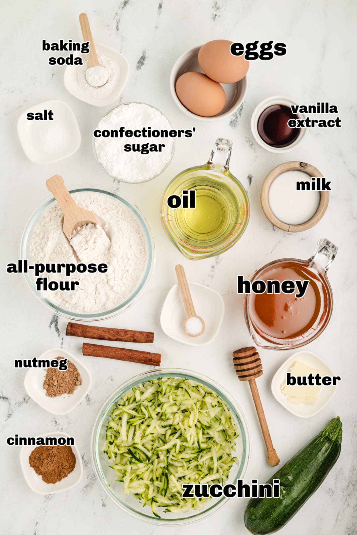 Overhead shot of ingredients for zucchini bread made with honey, flour, oil, and shredded zucchini