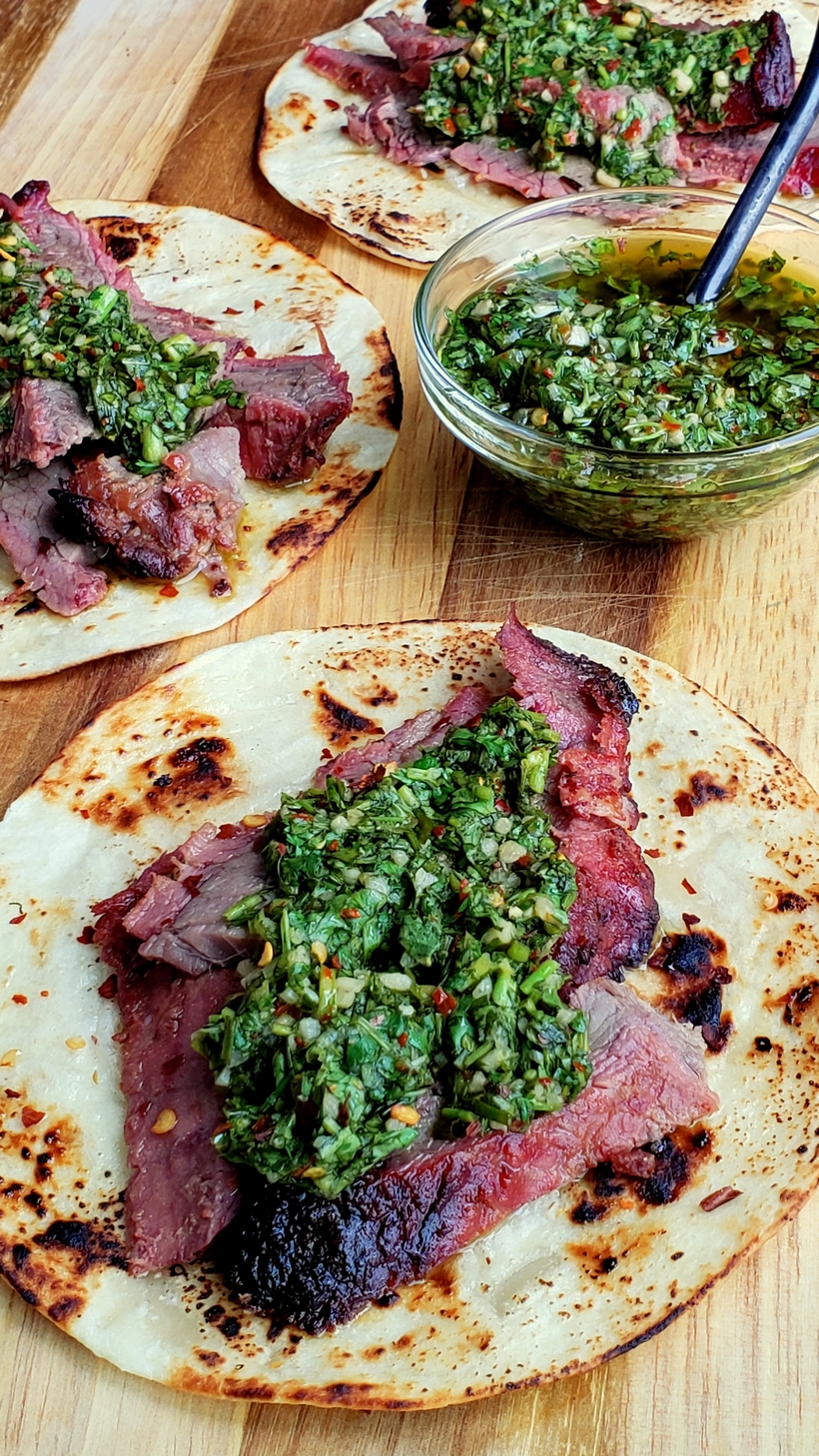 Three Flank Steak Tacos with Garlicky Cilantro Chimichurri with a bowl of chimichurri.