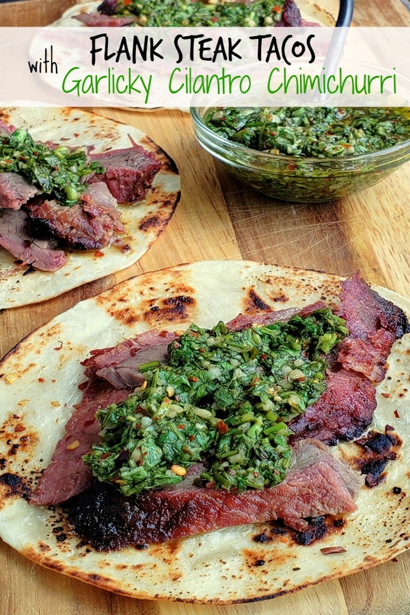 Text on photo reads Flank Steak Tacos with Garlicky Cilantro Chimichurri, with three tacos present and bowl of chimichurri.