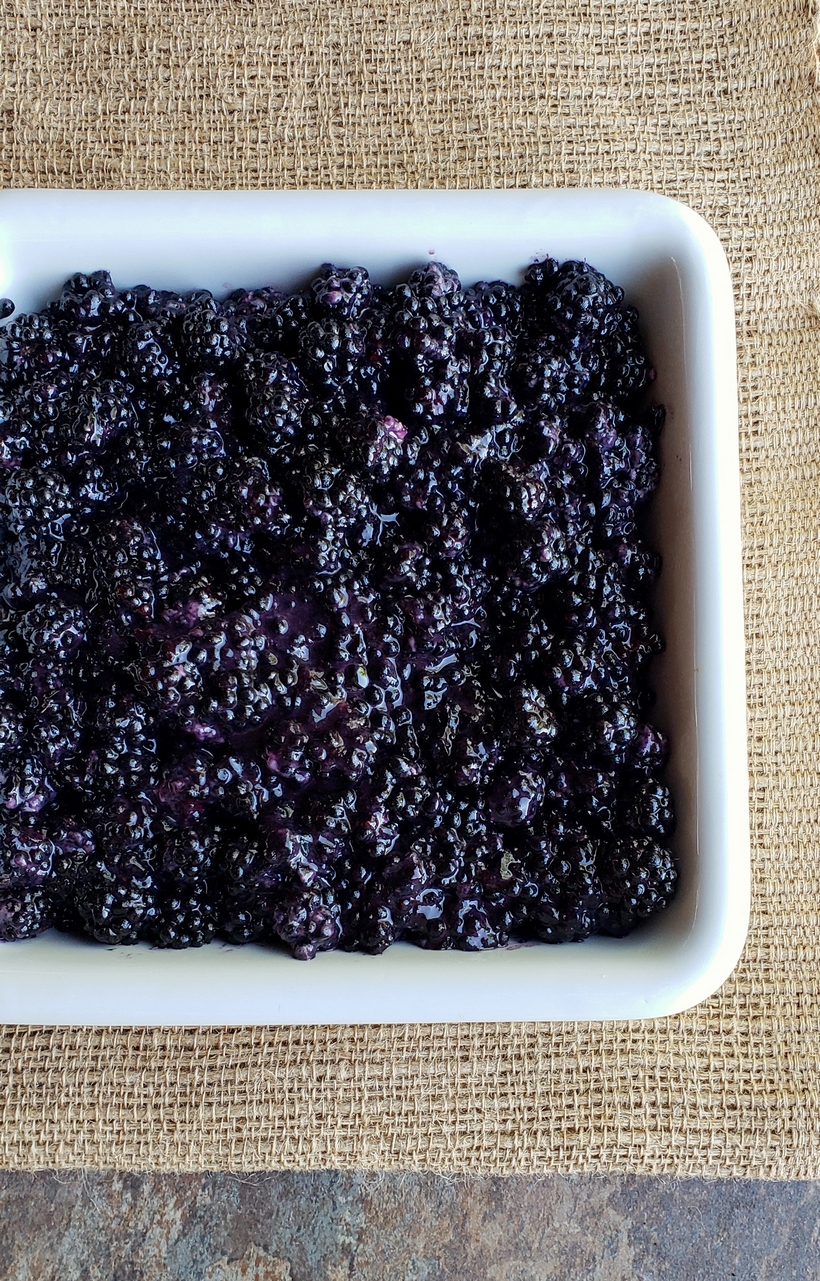 Nothing tastes more like late summer than a Blackberry Crumble. Even if you've never baked from scratch, you will find this recipe so easy to put together. #noblepig #blackberry #crumble #summerdessert Blackberry filling in a baking dish.
