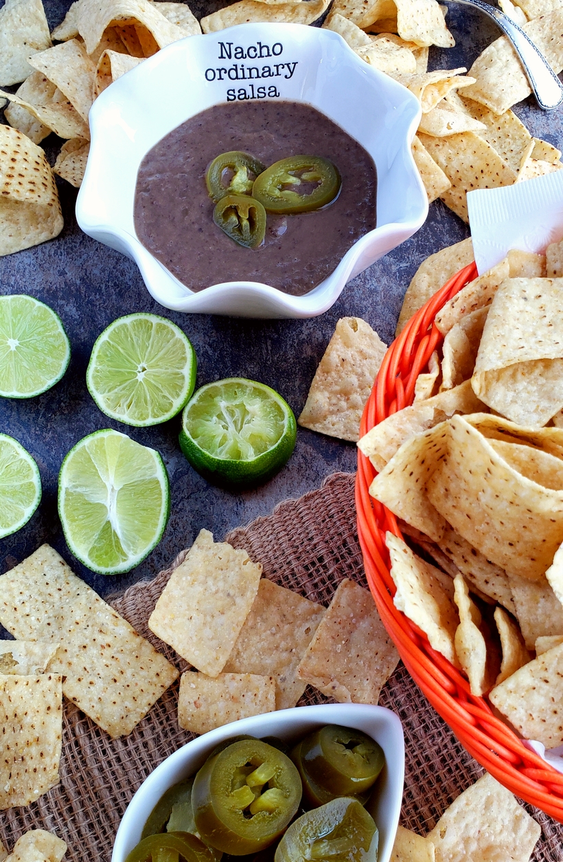You will be obsessed with this quick and easy 3-Ingredient Blender Salsa that is packed with flavor and spicy heat. Whether you pour it over tacos or use it for chips and dip, I guarantee it will become a fast favorite. #noblepig #salsa #gameday #easyrecipes Salsa in a bowl with chips and jalapenos.