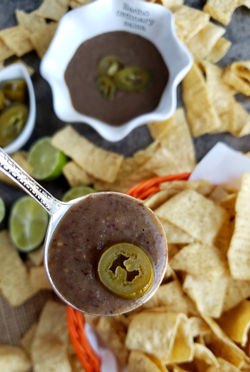 You will be obsessed with this quick and easy 3-Ingredient Blender Salsa that is packed with flavor and spicy heat. Whether you pour it over tacos or use it for chips and dip, I guarantee it will become a fast favorite. #noblepig #salsa #gameday #easyrecipes Three ingredient salsa in a bowl and spoon with corn chips.