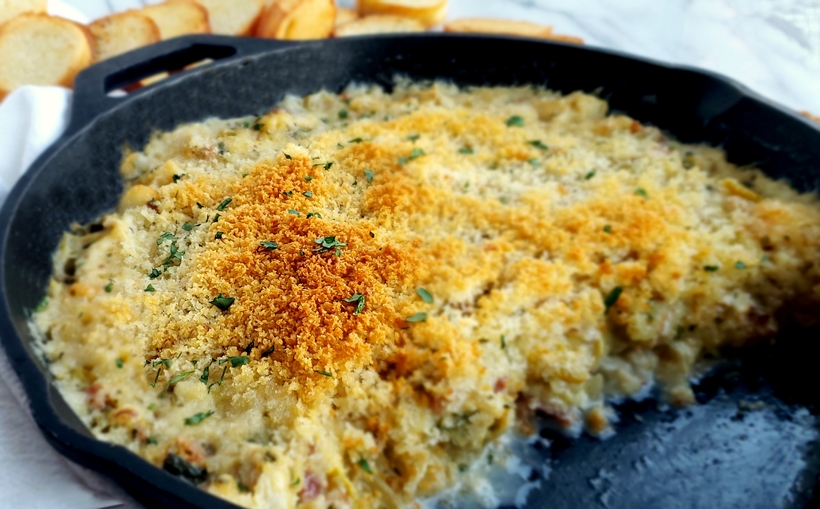 Buttery Brie cheese covered with a layer of baked bread crumbs reveals a hot dip packed with crab, artichoke and bacon. It doesn't get much better than this Warm Brie, Crab and Artichoke Dip! #noblepig #lowcarb #ketorecipe #crabdip