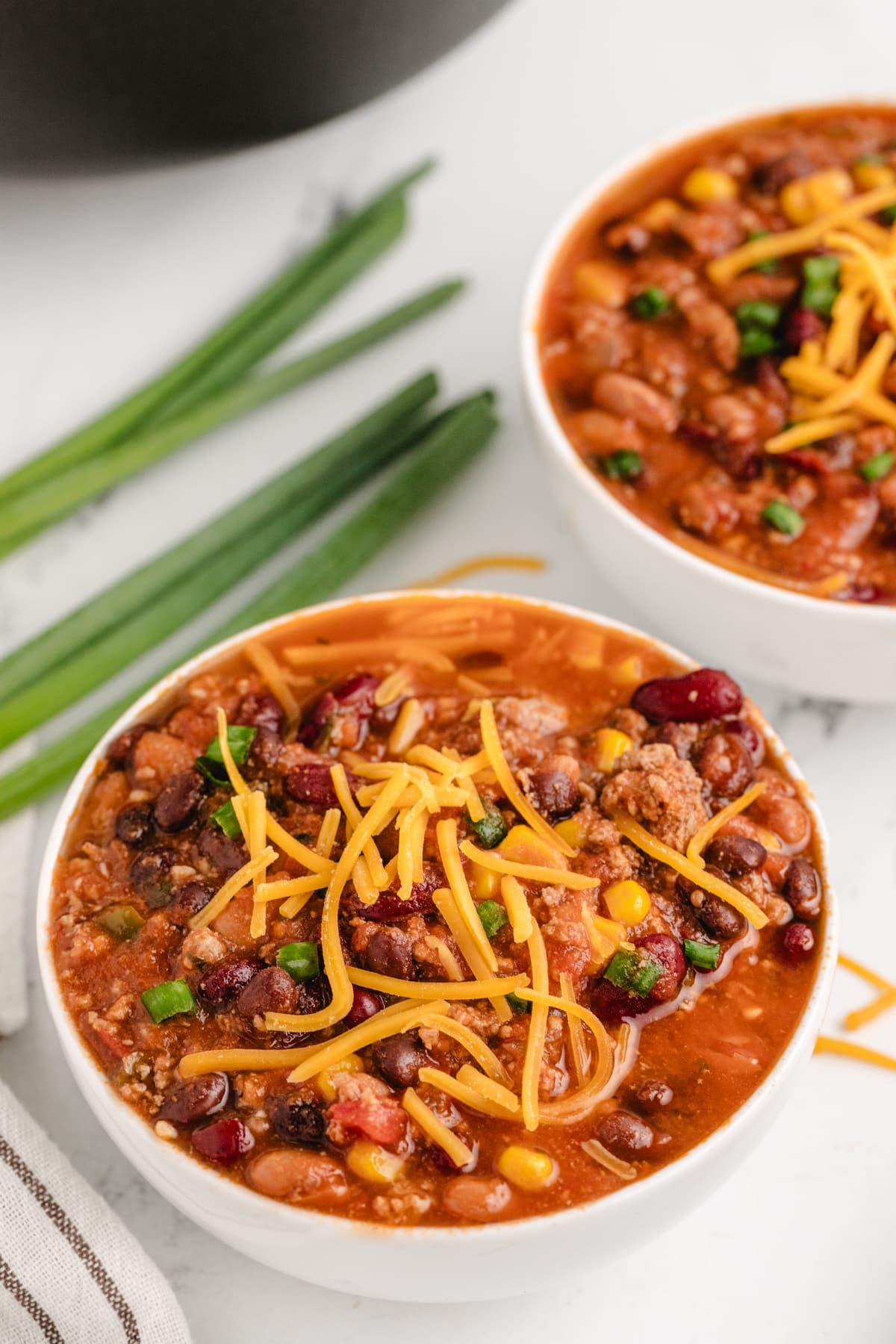 Healthy Turkey Chili with Cheese healthy turkey chili (low calorie) with shredded cheese on top for garnish
