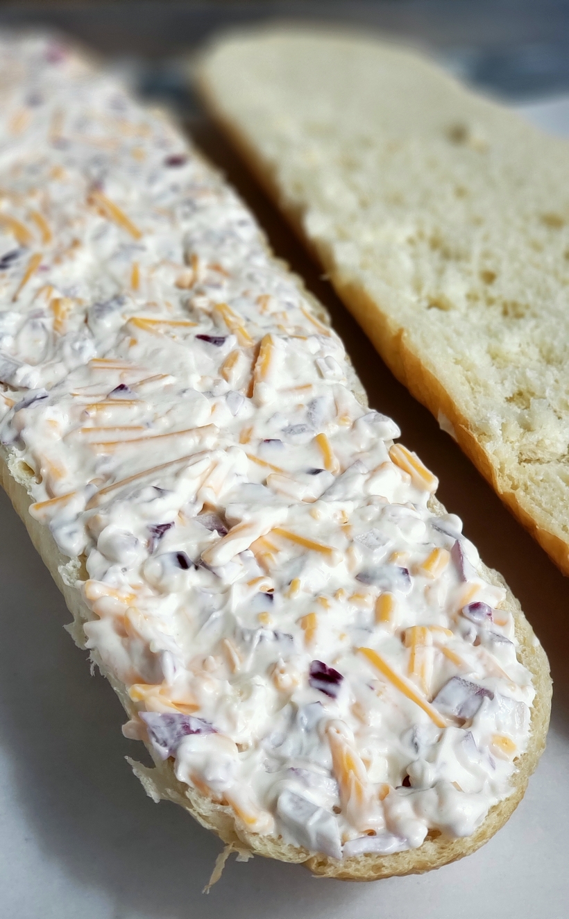 Cheesy Bread Spread will transform your regular loaf of bread into a mouthwatering sensation. Serve this bread with pasta dishes or next to a freshly made salad. #cheesybread