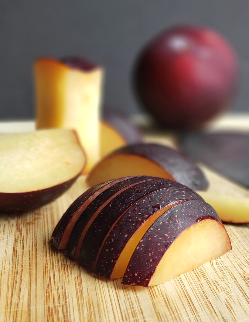 Sliced plums on a cutting board.