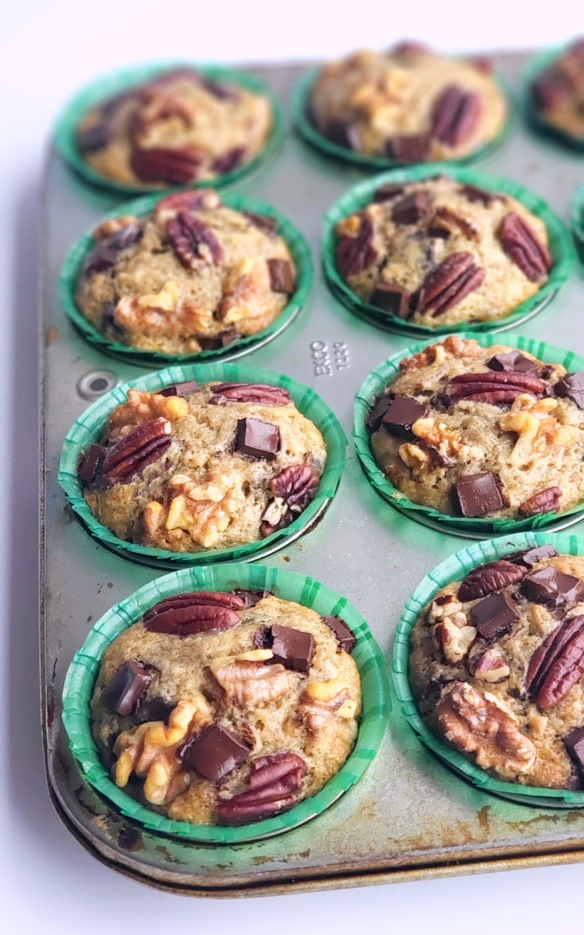 These Eggnog Banana Bread Muffins are tender, delicious and full of pure banana flavor. The eggnog lends a gentle nod to the holidays in a format that is perfect for celebrating Christmas brunch. This holiday breakfast muffin is the perfect cure to hunger while unwrapping those holiday gifts. #noblepig #eggnog #eggnogmuffins #eggnogbananamuffins #holidaybreakfastrecipes #holidaybreakfastideas #christmasbrunch #holidaymuffinrecipe #fluffyeggnogmuffins #christmasbreakfast #muffins #muffinrecipe These Eggnog Banana Bread Muffins are baked and sitting in a muffin tin.