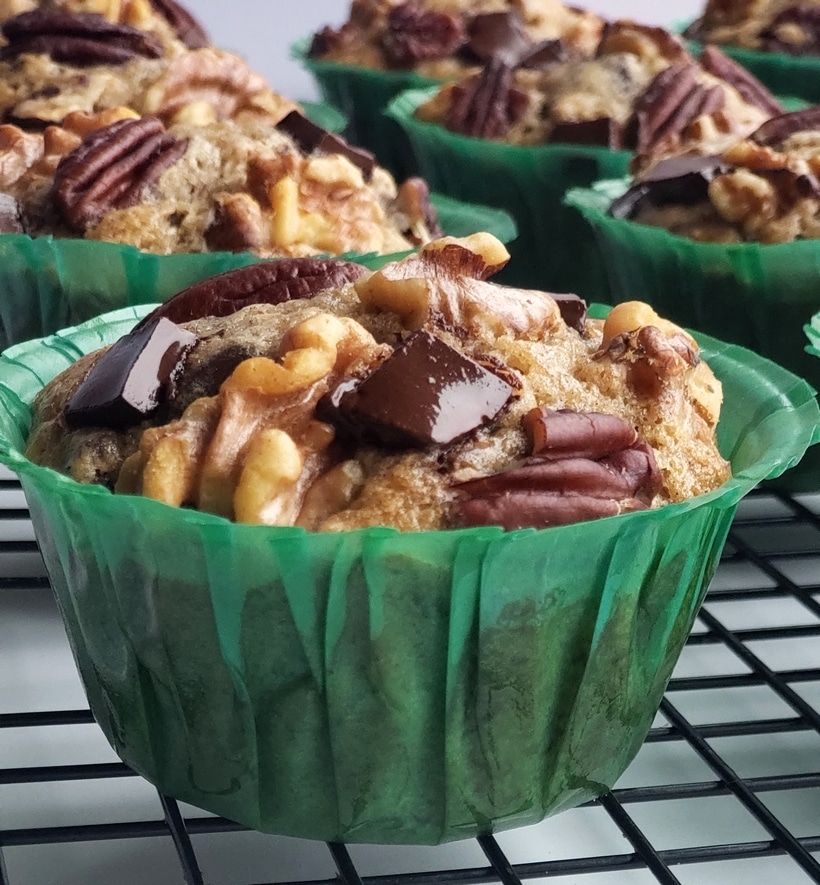 These Eggnog Banana Bread Muffins are tender, delicious and full of pure banana flavor. The eggnog lends a gentle nod to the holidays in a format that is perfect for celebrating Christmas brunch. This holiday breakfast muffin is the perfect cure to hunger while unwrapping those holiday gifts. #noblepig #eggnog #eggnogmuffins #eggnogbananamuffins #holidaybreakfastrecipes #holidaybreakfastideas #christmasbrunch #holidaymuffinrecipe #fluffyeggnogmuffins #christmasbreakfast #muffins #muffinrecipe Close up of Eggnog Banana Bread Muffins