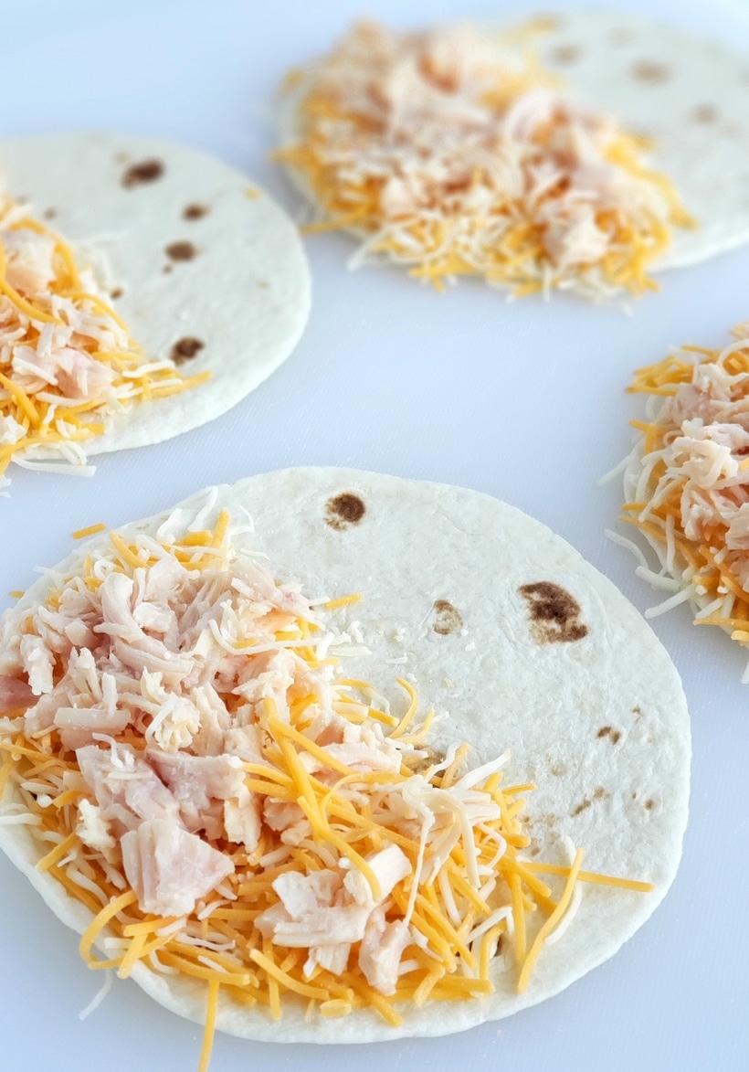 Preparation of chicken quesadillas on a flour tortilla.