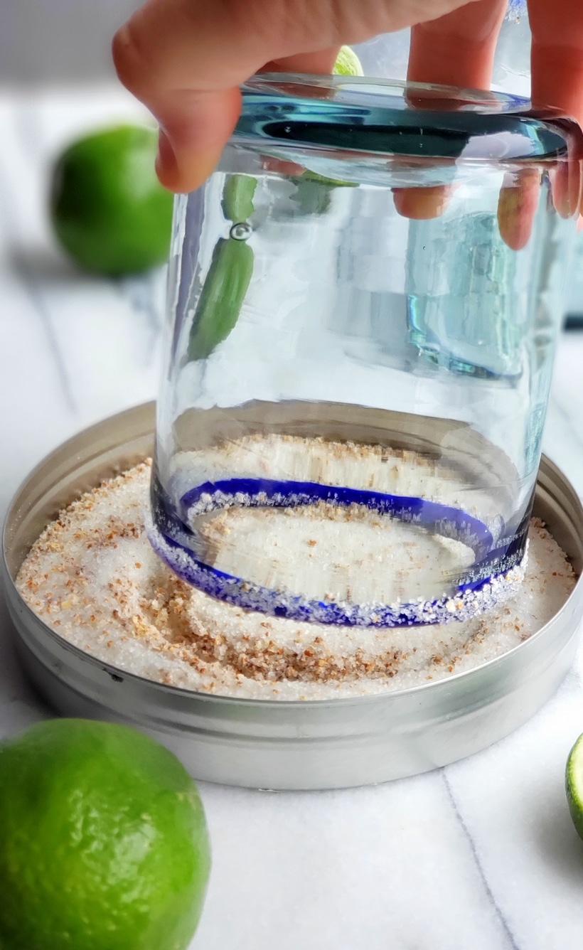 Margarita glass being dipped in margarita salt.