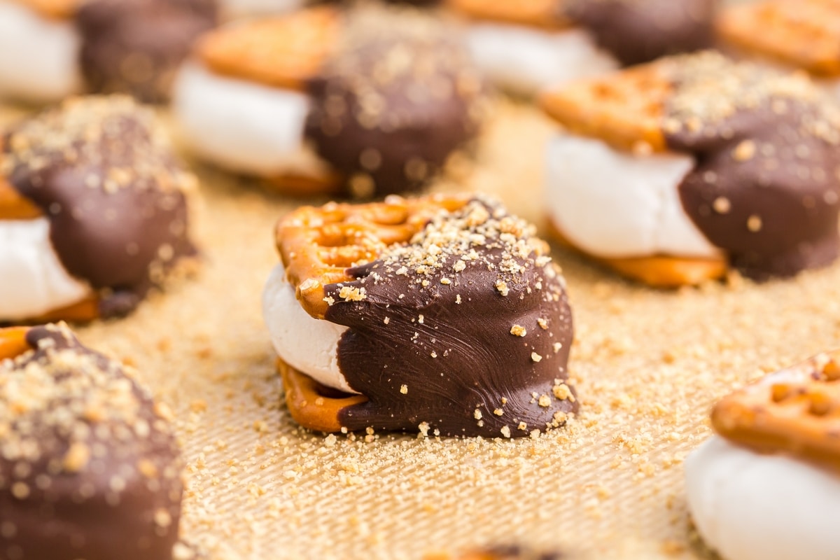 S’mores pretzel bites on a baking mat with melty chocolate and marshmallow centers