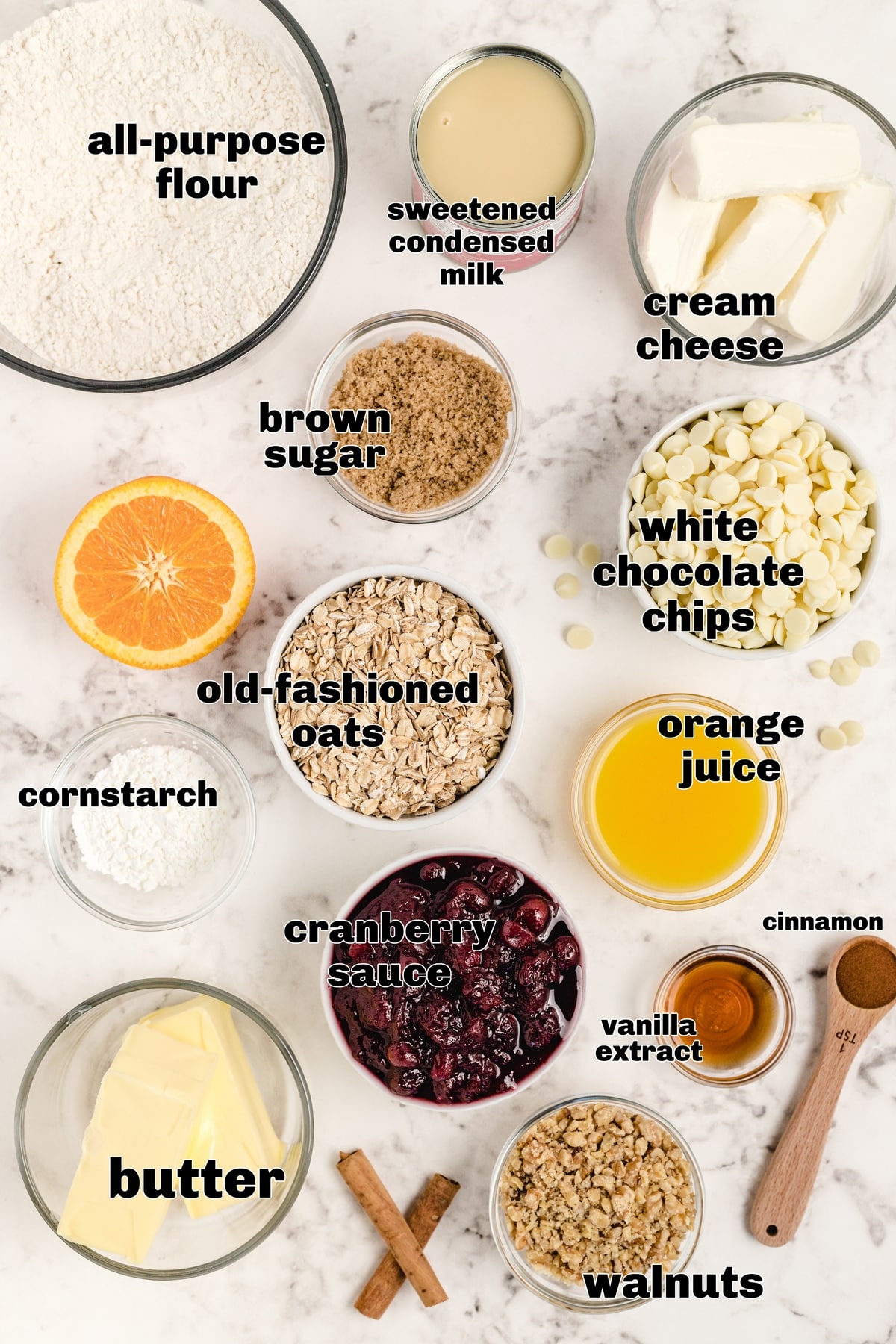Ingredients for Making Cranberry Bars Ingredients for cream cheese cranberry bars, including oats, cranberries, cream cheese, and white chocolate chips, arranged on a counter.
