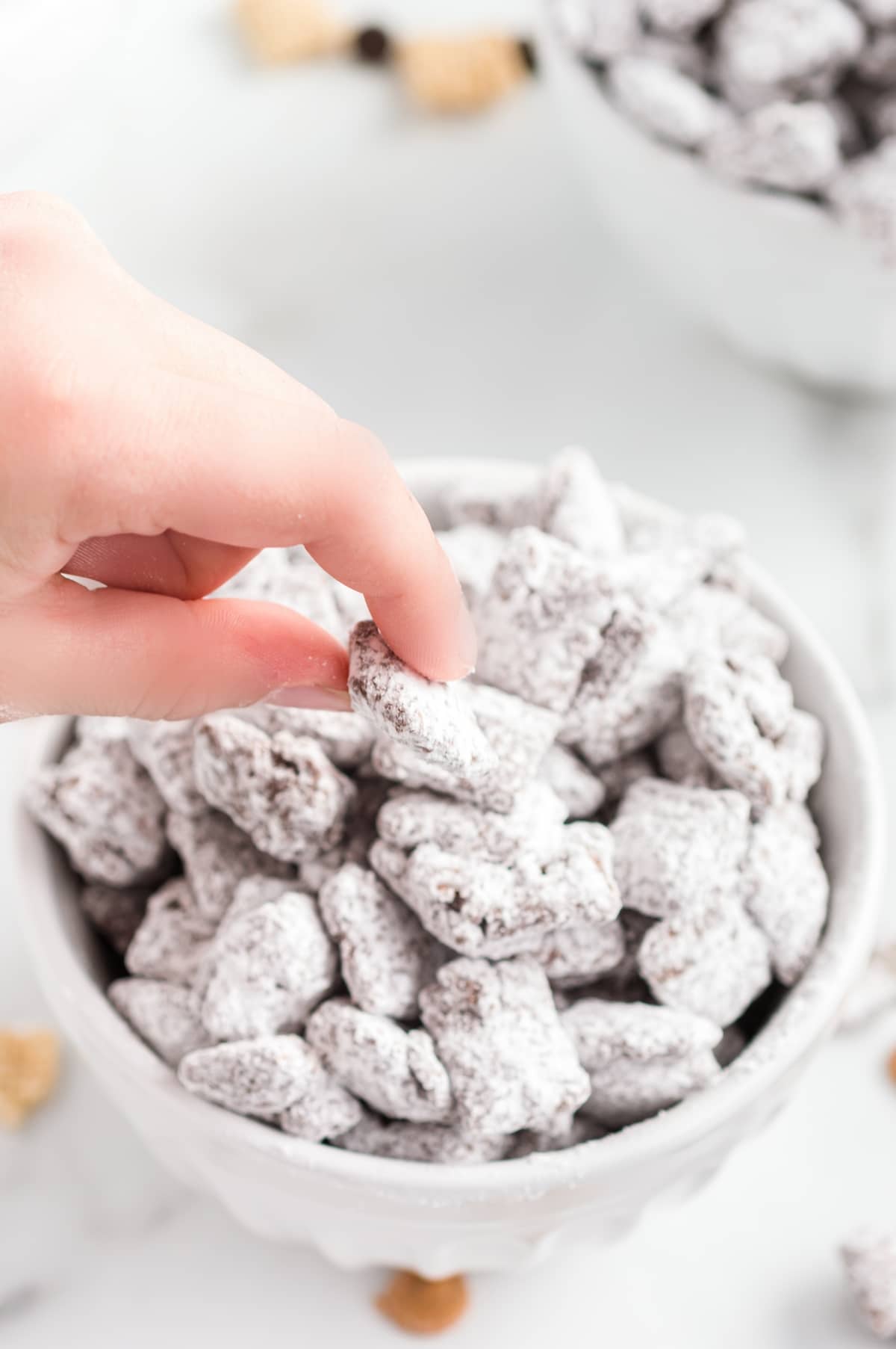 a hand taking a serving of puppy chow