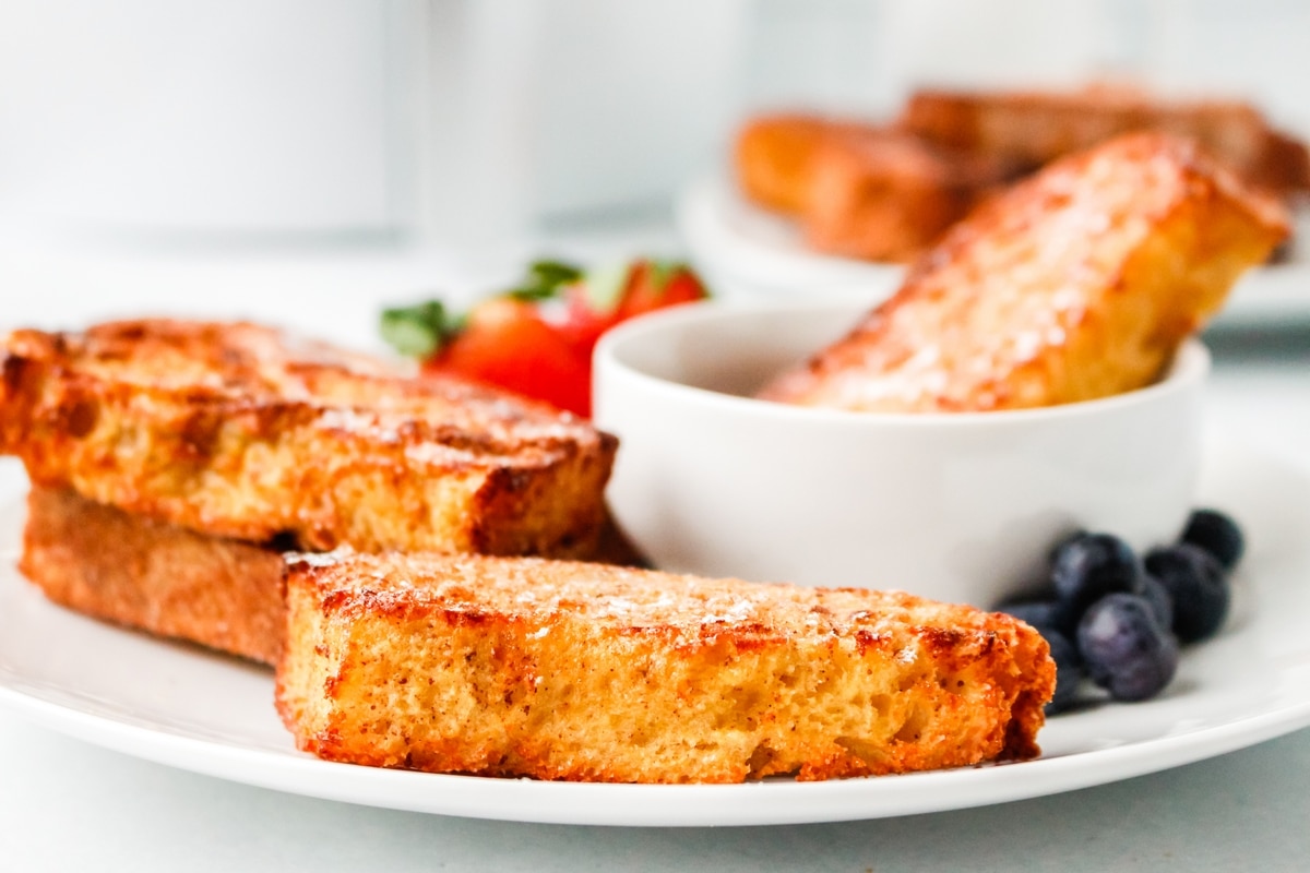 Air Fryer French Toast on a plate. air fryer French toast on a white plate with fruit