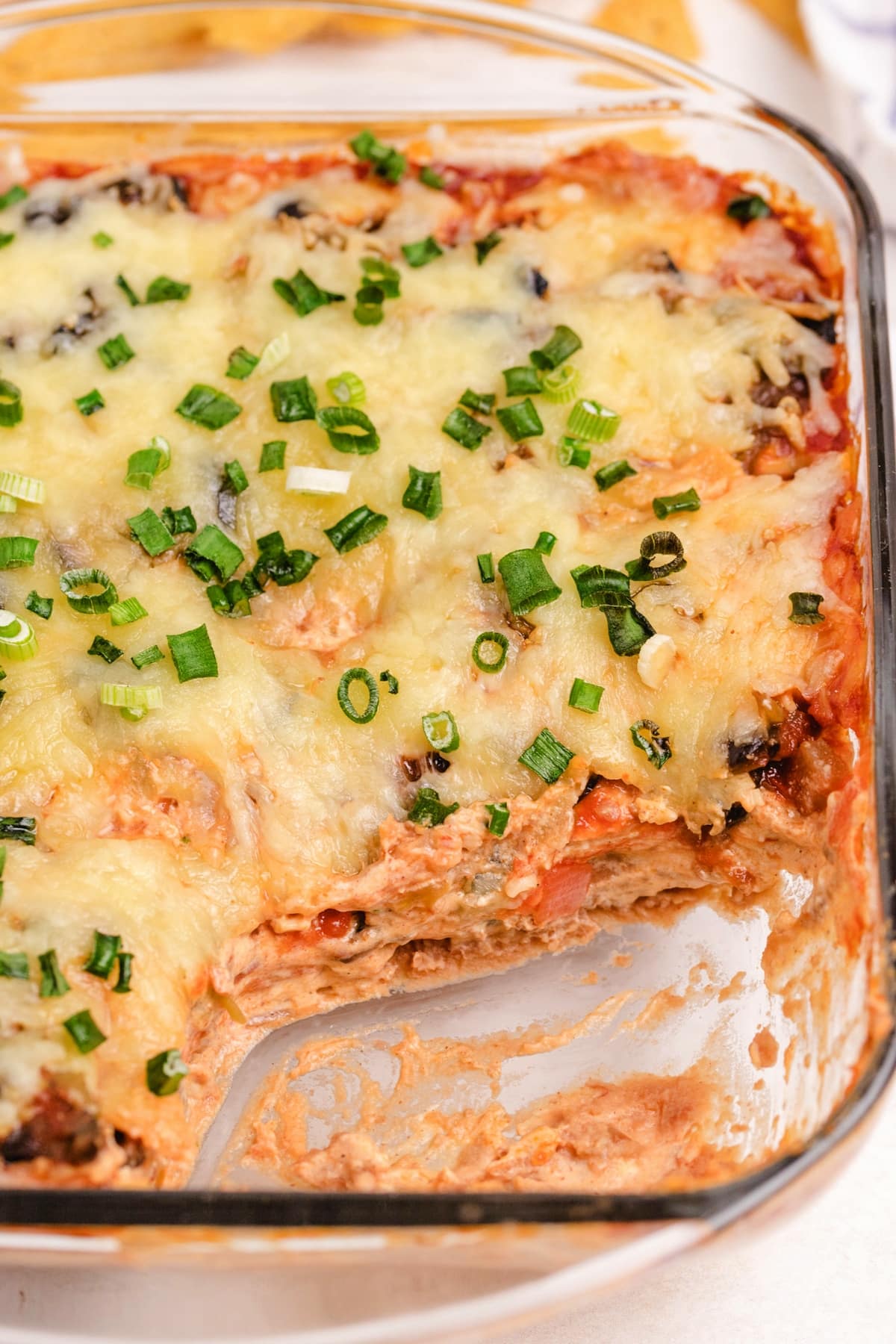 Zoomed-in overhead shot of the baked taco dip, showing the melted cheese and toppings before serving.
