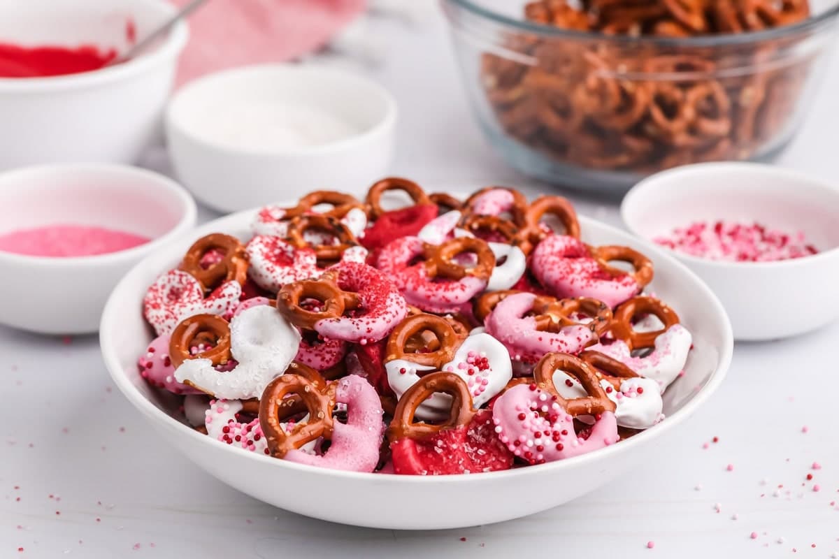 A small bowl of finished chocolate-dipped pretzels, showing the mix of colors and textures.