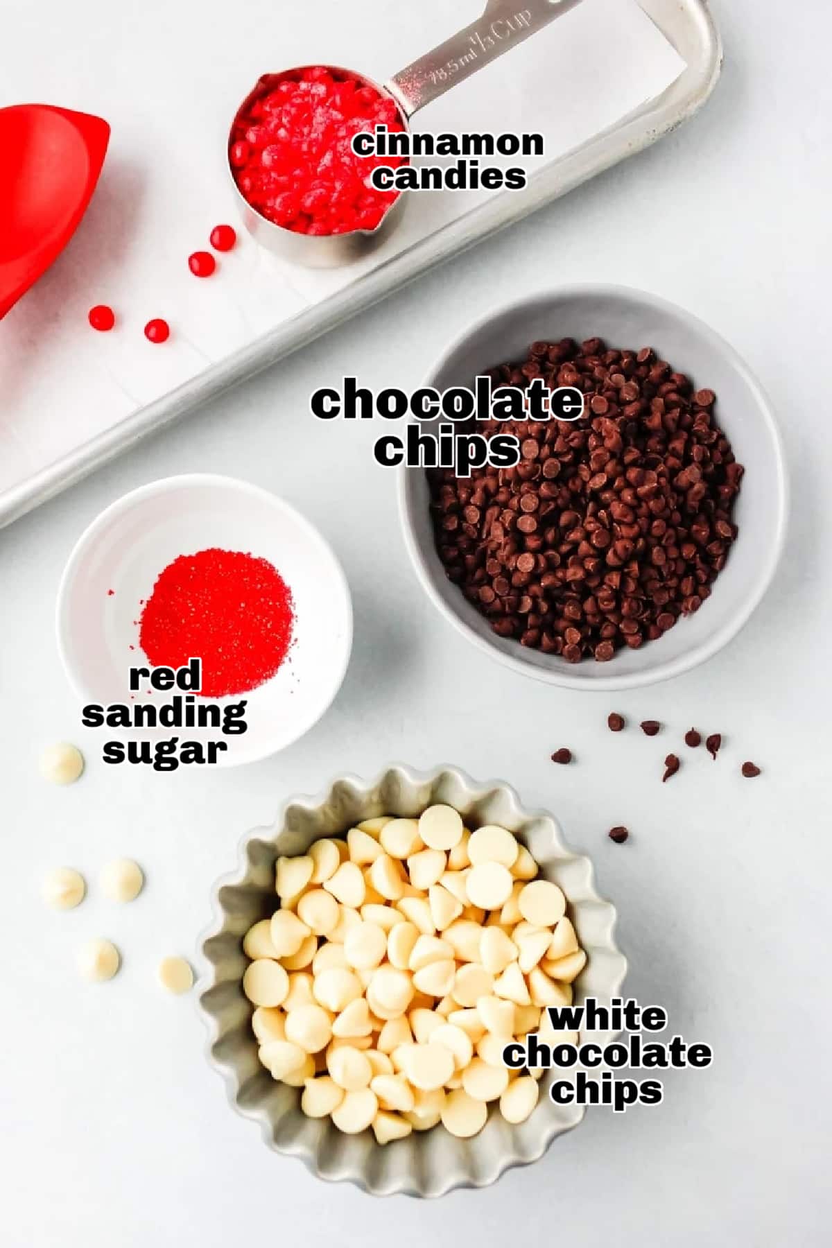 Valentine's Day Chocolate Bark ingredients A flat lay of ingredients, including chocolate chips, white chocolate chips, cinnamon candies, and sanding sugar.