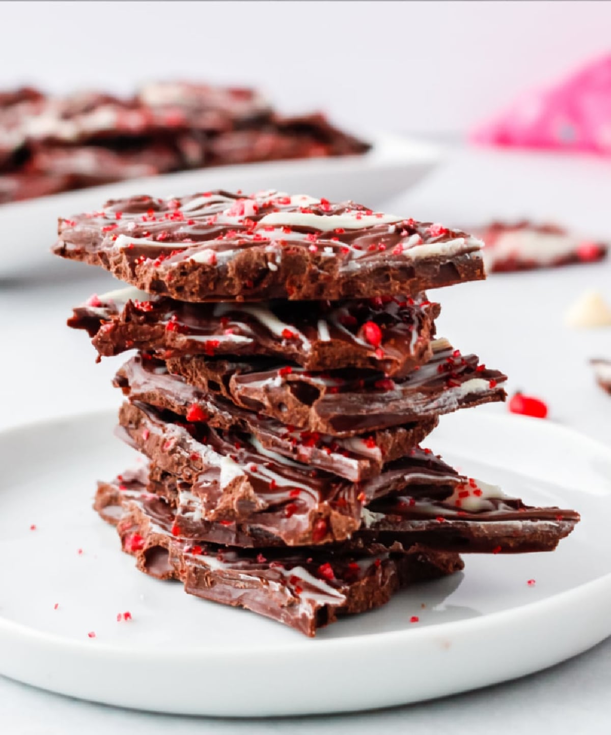 Valentine's Day Chocolate Bark in a stack A stack of Valentine’s Day chocolate bark pieces, showing the swirled chocolate layers and crushed cinnamon candy topping.