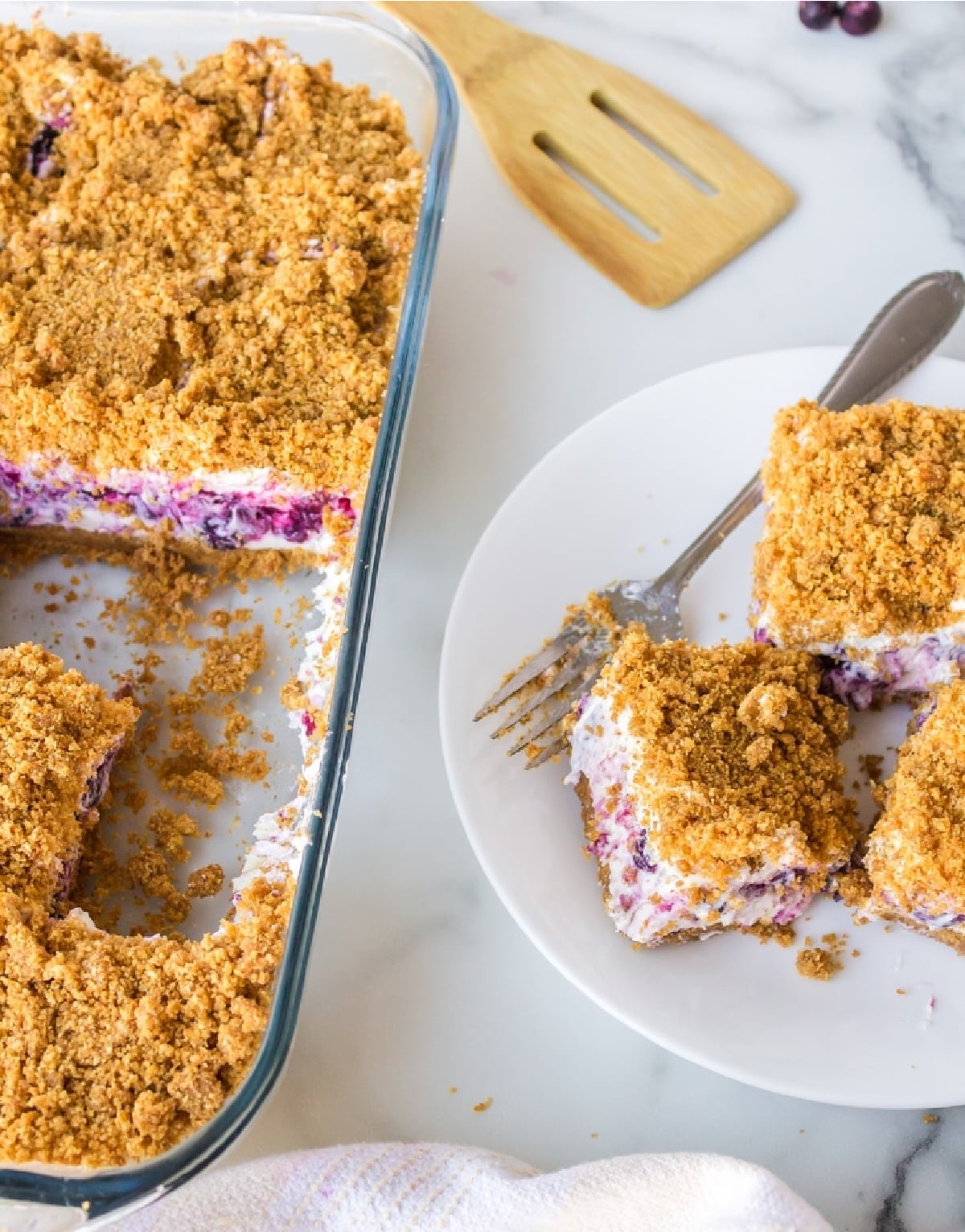 Blueberry Cheesecake Icebox Cake with slices served Overhead shot of blueberry cheesecake icebox cake with three slices on a plate