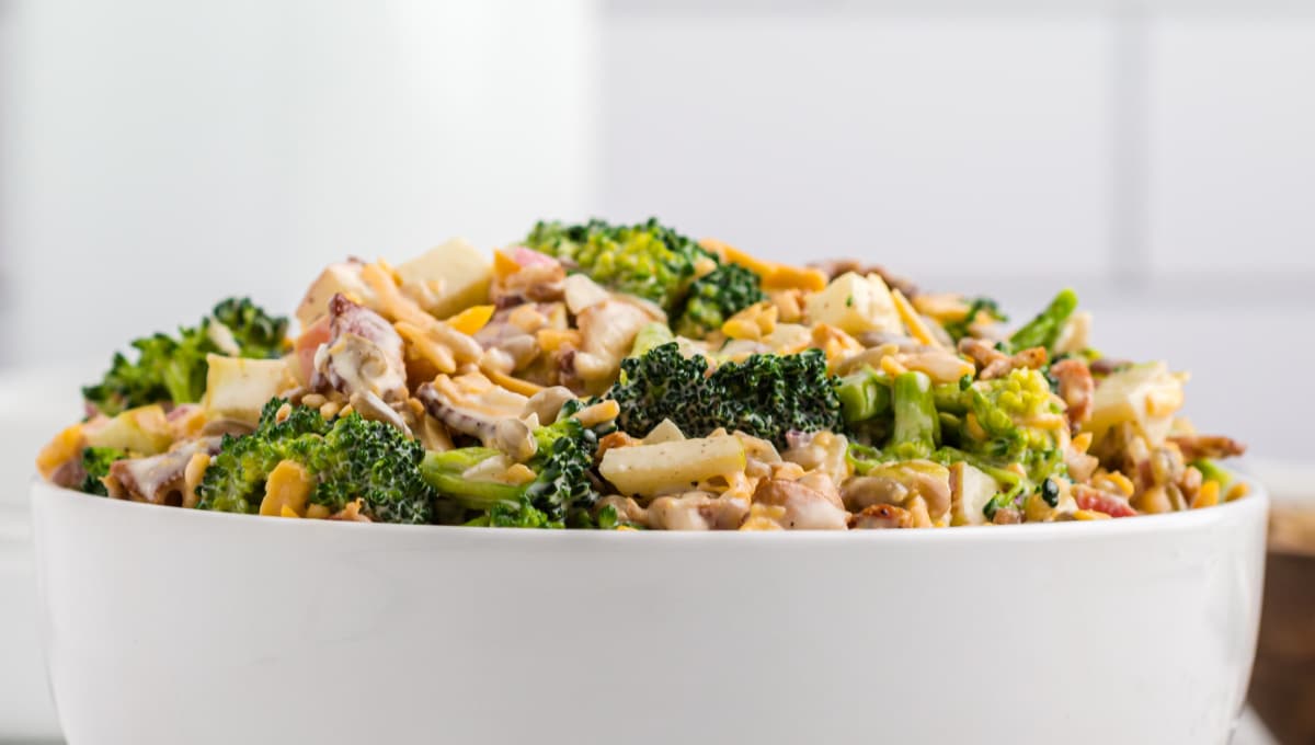 Bacon Broccoli Salad side view A side-angle shot of the salad in a serving bowl, highlighting the layers of ingredients and the creamy dressing coating everything.