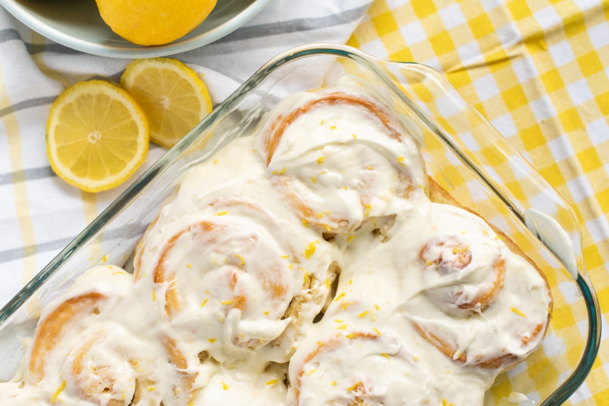 Lemon Buns with Lemon Cream Cheese Icing top view Freshly baked lemon buns in a rectangular baking dish, golden brown and swirled with lemon filling.