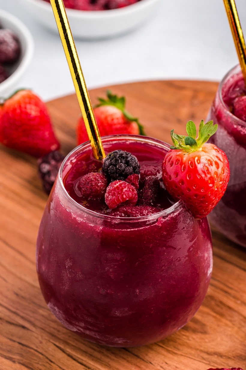 Red wine slushie beginning to melt in a glass on a warm surface