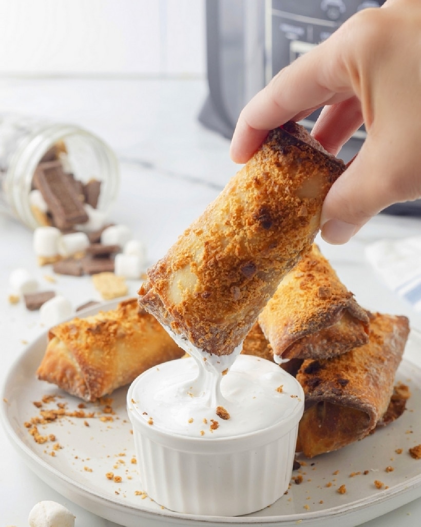 These air fryer s'mores egg rolls are a perfect twist on a classic campfire treat. They're filled with melted chocolate and marshmallows inside and served with extra marshmallow fluff on the side for dipping. This cooking method makes s'mores a year-round treat. Air Fryer S'mores egg rolls
