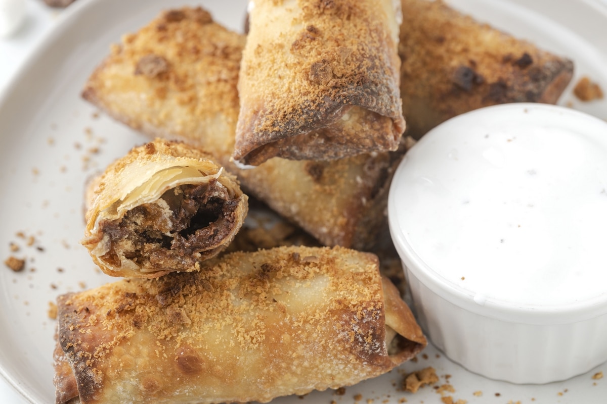 These air fryer s'mores egg rolls are a perfect twist on a classic campfire treat. They're filled with melted chocolate and marshmallows inside and served with extra marshmallow fluff on the side for dipping. This cooking method makes s'mores a year-round treat. air fryer s'mores