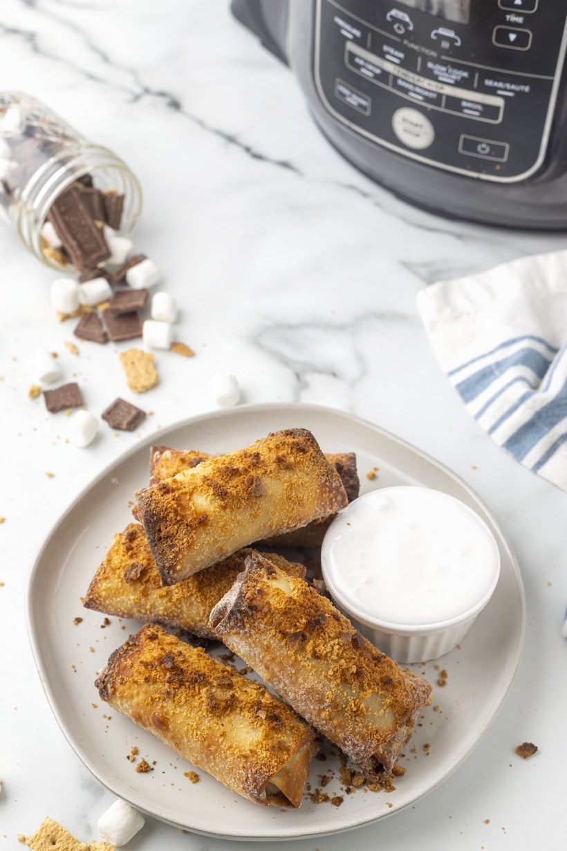 Air-fried and crispy on the outside, these s'mores egg rolls are filled with melted chocolate and marshmallows on the inside, with extra marshmallow fluff served on the outside to dunk into. The perfect twist on a campfire treat. smores egg rolls