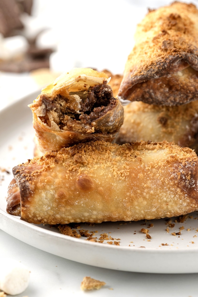 Air-fried and crispy on the outside, these s'mores egg rolls are filled with melted chocolate and marshmallows on the inside, with extra marshmallow fluff served on the outside to dunk into. The perfect twist on a campfire treat. crispy smores egg rolls