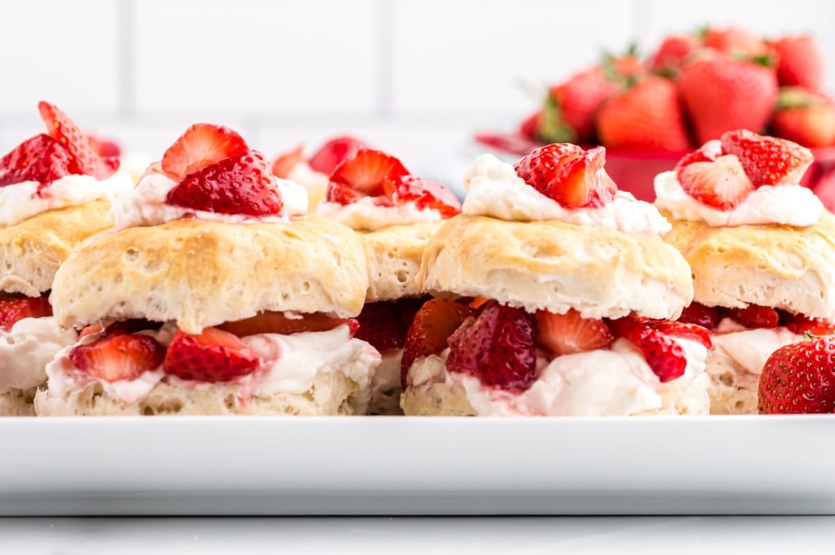 easy strawberry shortcake served on a platter with whipped cream and fresh strawberries