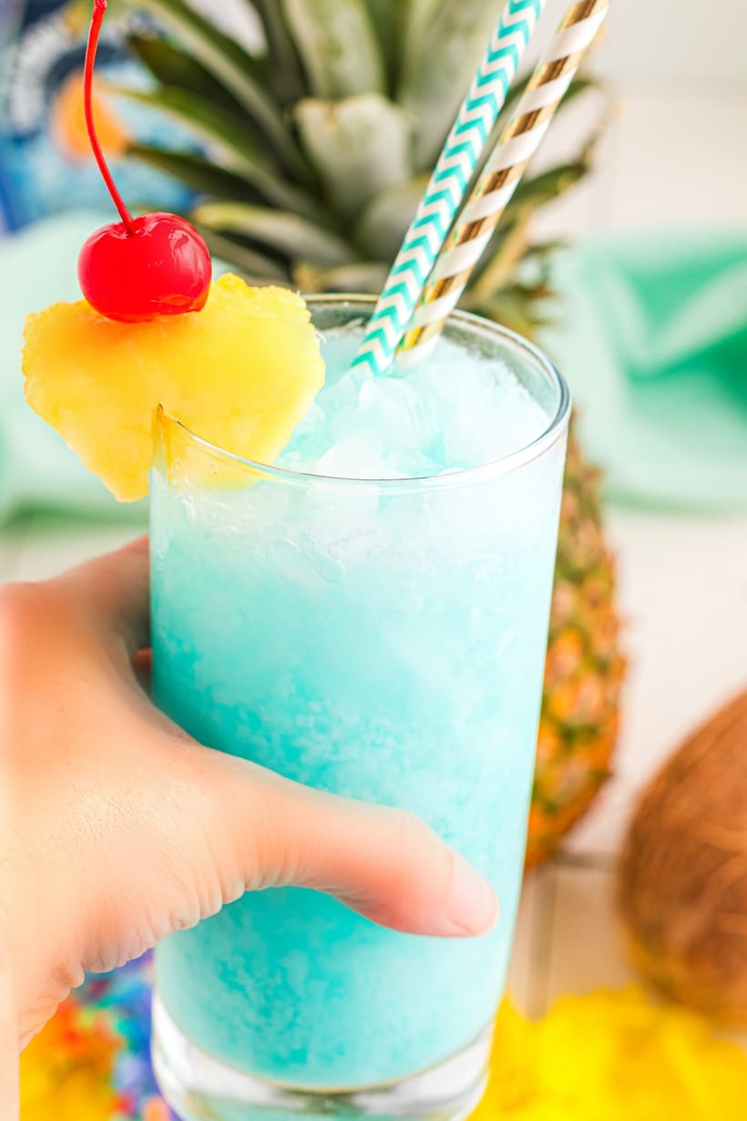 This blue Hawaiian cocktail tastes like a vacation in a glass. With pineapple, coconut, and a splash of blue curaçao, it’s perfect for summer parties or serving at a luau! Blue Hawaiian cocktail in a tall glass with pineapple wedge and cherry garnish