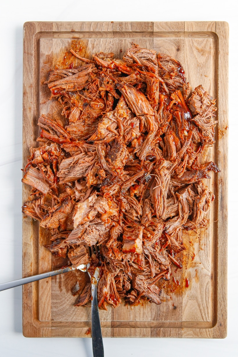 shredded chuck roast on a cutting board